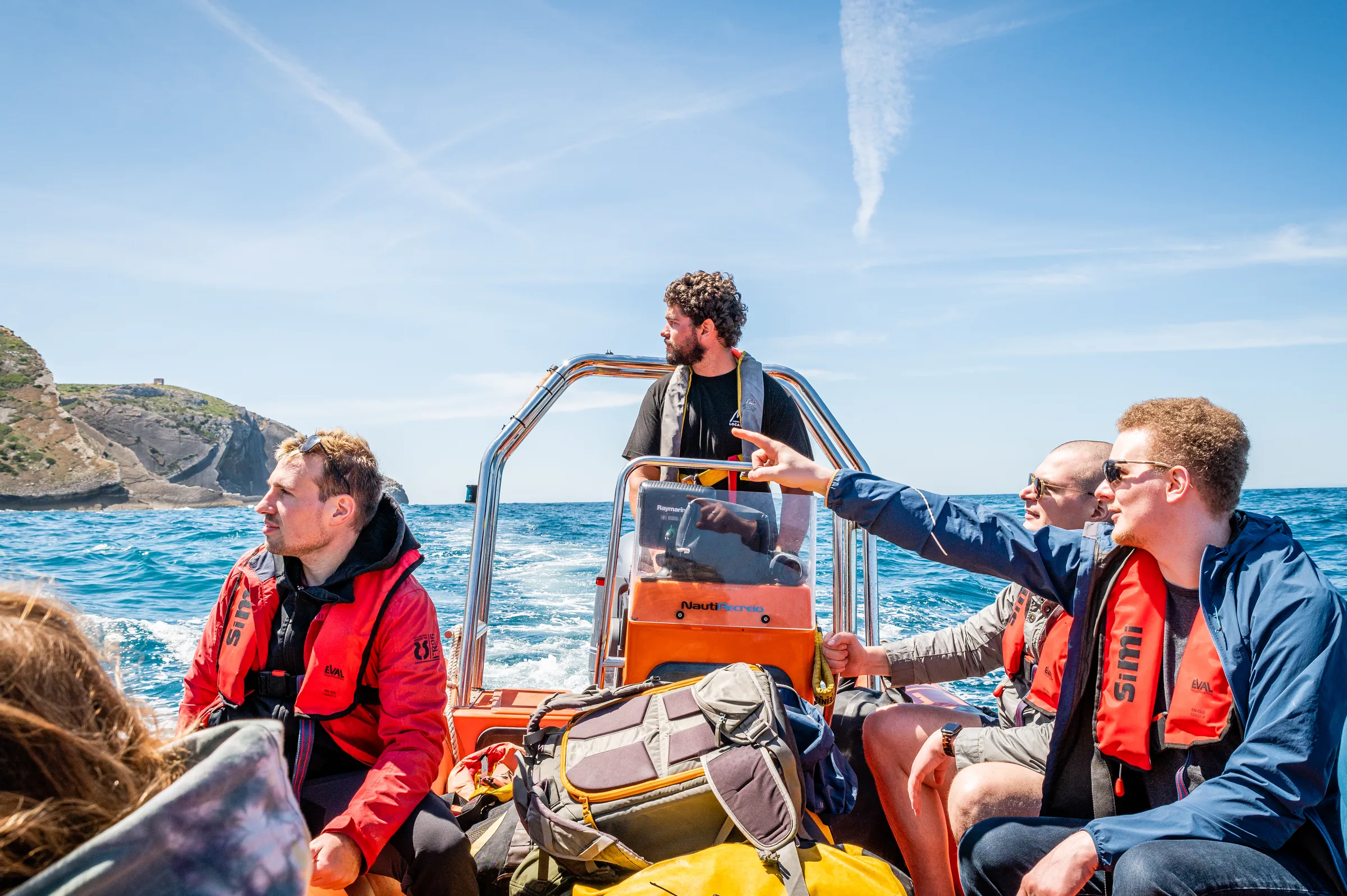 codejoi team members sitting together on a boat during an offsite by the sea